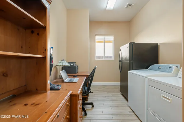 a view of a workspace with furniture and wooden floor