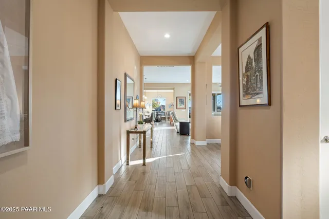 a view of a hallway with wooden floor windows and a kitchen