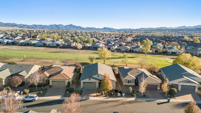 an aerial view of residential houses with outdoor space and ocean view