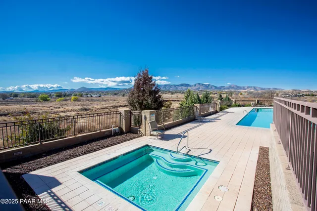 a view of a swimming pool with a bench and trees in the background