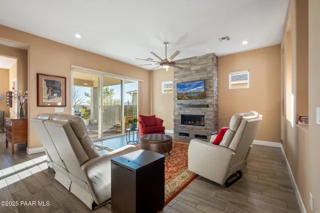 a living room with furniture a fireplace and a floor to ceiling window
