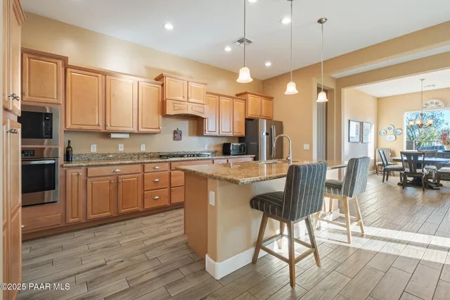 a kitchen with a table chairs microwave and cabinets