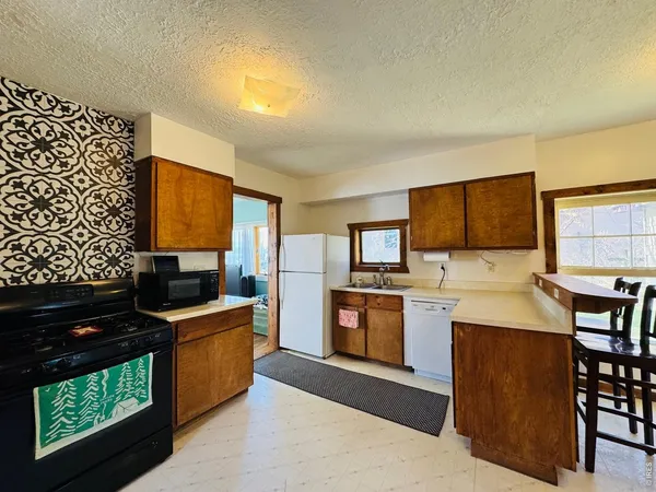 a kitchen with granite countertop a stove top oven sink and cabinets