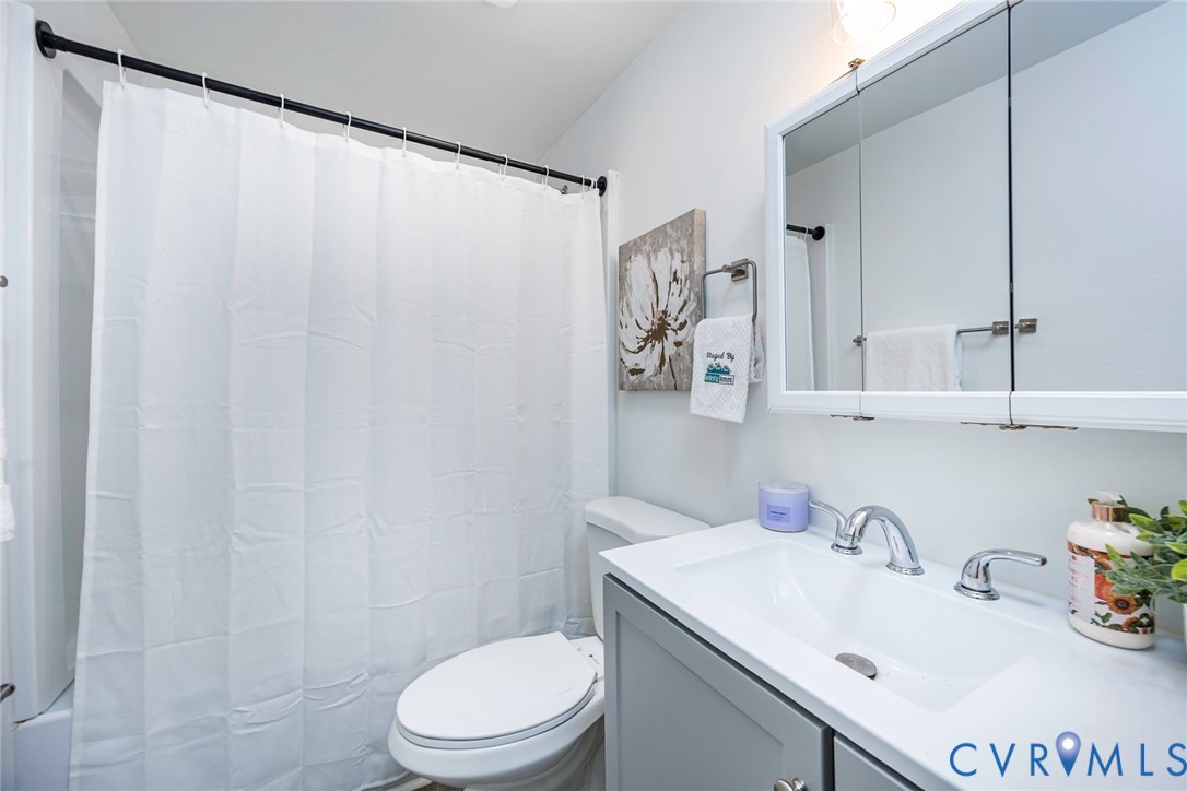 9406 Kendrick Road Chesterfield, VA 23236 - Photo 11 of 15 White-tiled shower with a black curtain rod, a whi