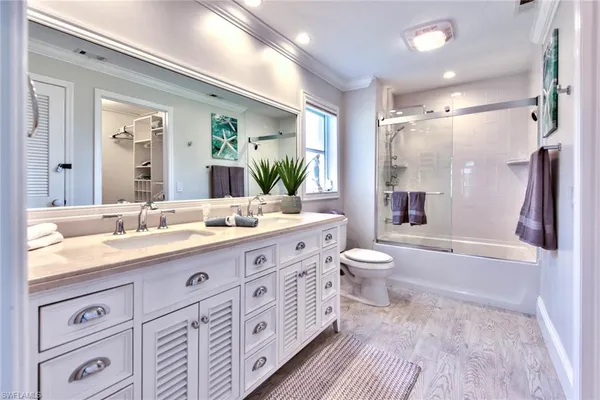 a spacious bathroom with a granite countertop sink toilet a large mirror a bathtub and shower