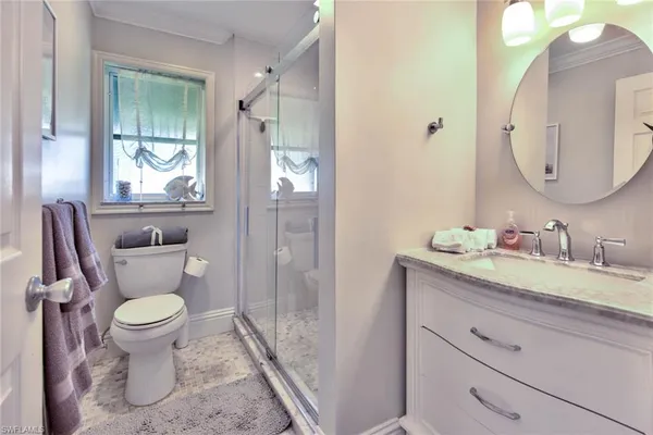 a bathroom with a granite countertop toilet sink and mirror