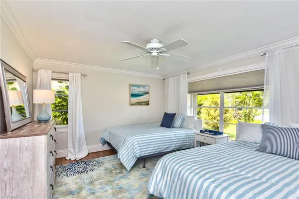 a bedroom with two beds and a large window