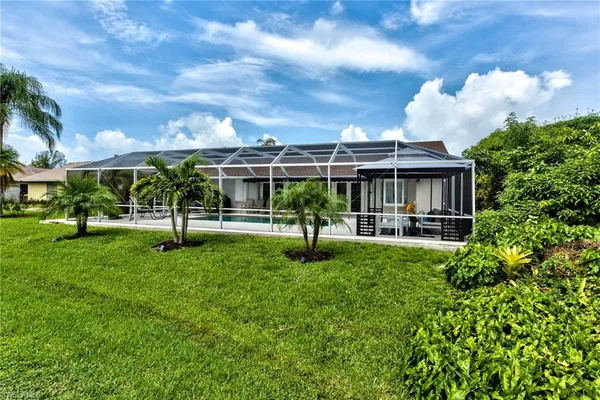 a view of a house with backyard and sitting area