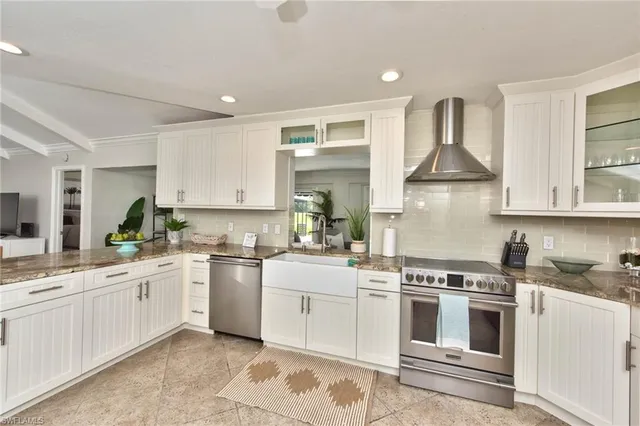 a kitchen with white cabinets stainless steel appliances and sink