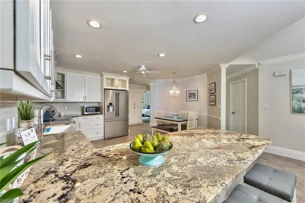 a kitchen with sink refrigerator dining table and chairs