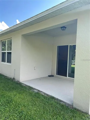 a backyard of a house with plants and tree