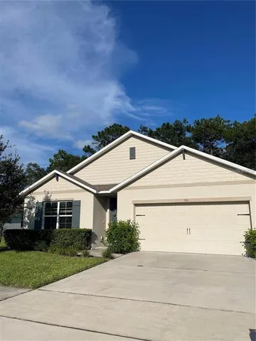 a front view of a house with a garden and plants