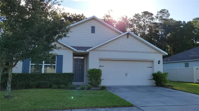 a front view of a house with a yard and trees