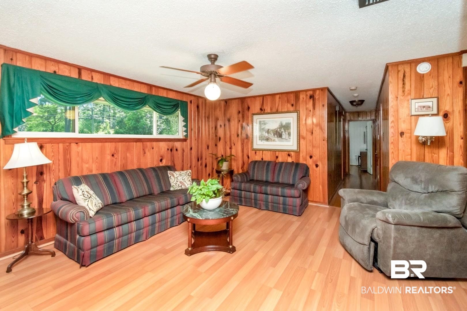 6300 Woodcrest Drive Mobile, AL 36608 - Photo 7 of 35 Living room with a textured ceiling, wood finished floors, wood walls, and a ceiling fan