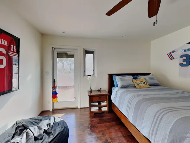 a bedroom with a bed and wooden floor