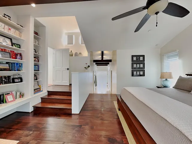 a spacious bedroom with a bed and a book shelf