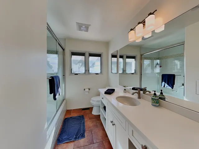 a bathroom with a sink a mirror and glass door