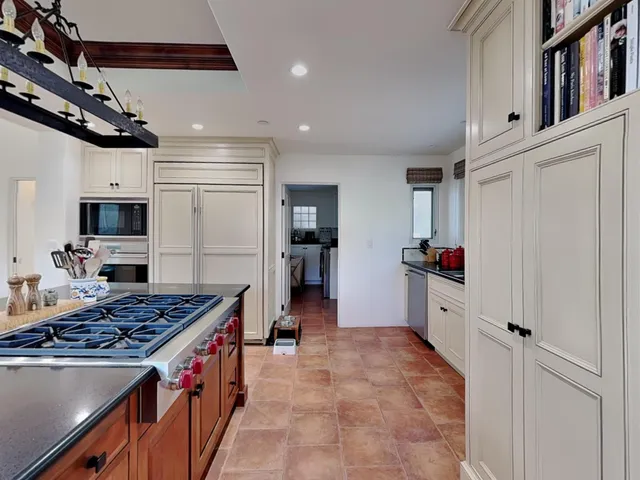 a kitchen with kitchen island a counter top space a sink stainless steel appliances and cabinets