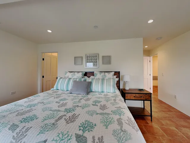 a large bedroom with a bed and wooden floor
