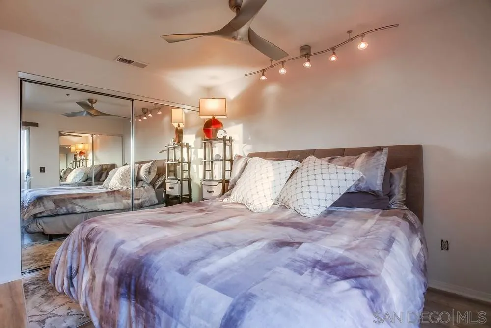 157 Mangano Circle Encinitas, CA 92024 - Photo 11 of 28 a bedroom with a large bed and a chandelier