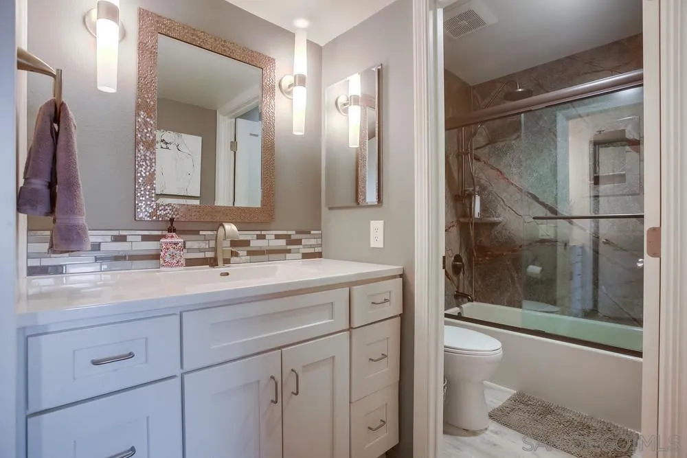 157 Mangano Circle Encinitas, CA 92024 - Photo 14 of 28 a bathroom with a shower sink vanity and mirror