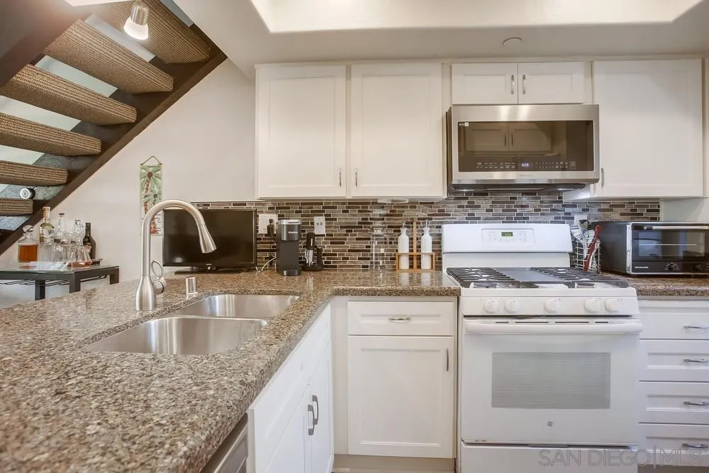 157 Mangano Circle Encinitas, CA 92024 - Photo 8 of 28 a kitchen with granite countertop a sink and a stove top oven