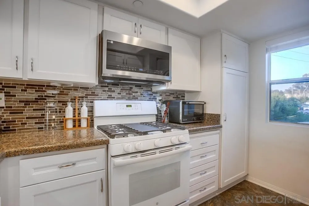 157 Mangano Circle Encinitas, CA 92024 - Photo 9 of 28 a kitchen with granite countertop a stove sink and microwave