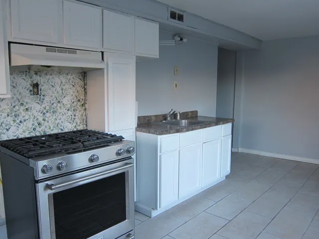 a stove top oven sitting inside of a kitchen