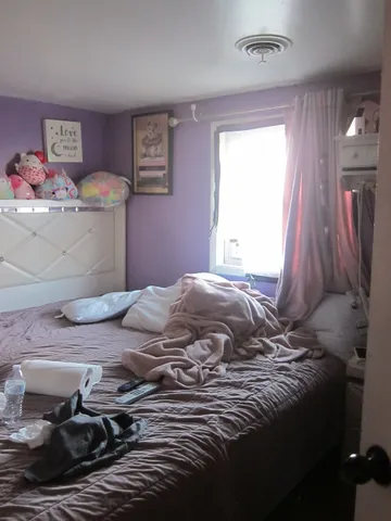 a bedroom with a bed and a window