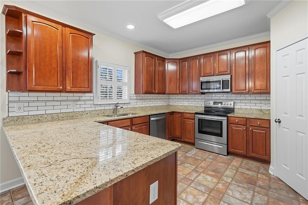 2301 Alexander Farms Court Southwest Marietta, GA 30064 - Photo 21 of 62 a kitchen with stainless steel appliances granite countertop a stove sink and cabinets
