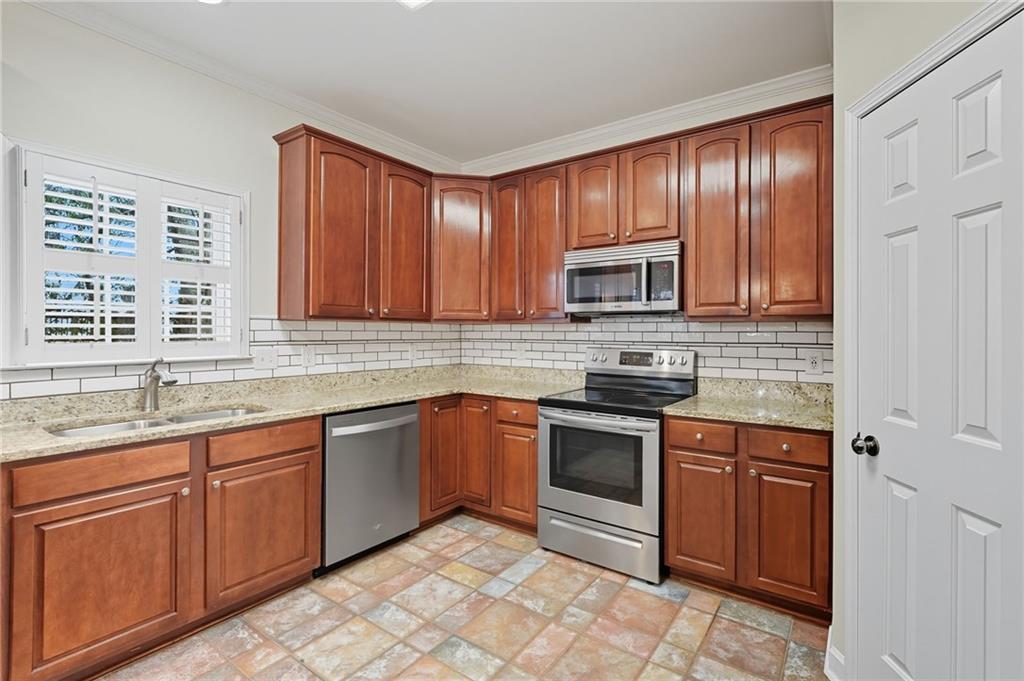 2301 Alexander Farms Court Southwest Marietta, GA 30064 - Photo 22 of 62 a kitchen with stainless steel appliances granite countertop wooden cabinets a stove top oven a sink and dishwasher
