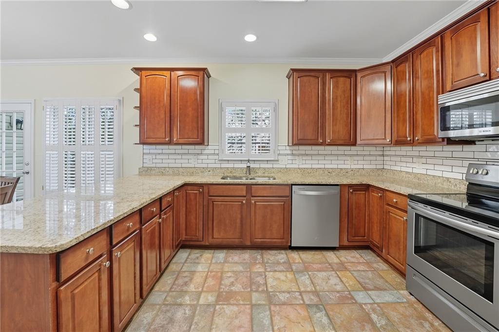 2301 Alexander Farms Court Southwest Marietta, GA 30064 - Photo 24 of 62 a kitchen with stainless steel appliances granite countertop wooden cabinets a sink and dishwasher a stove with wooden floor