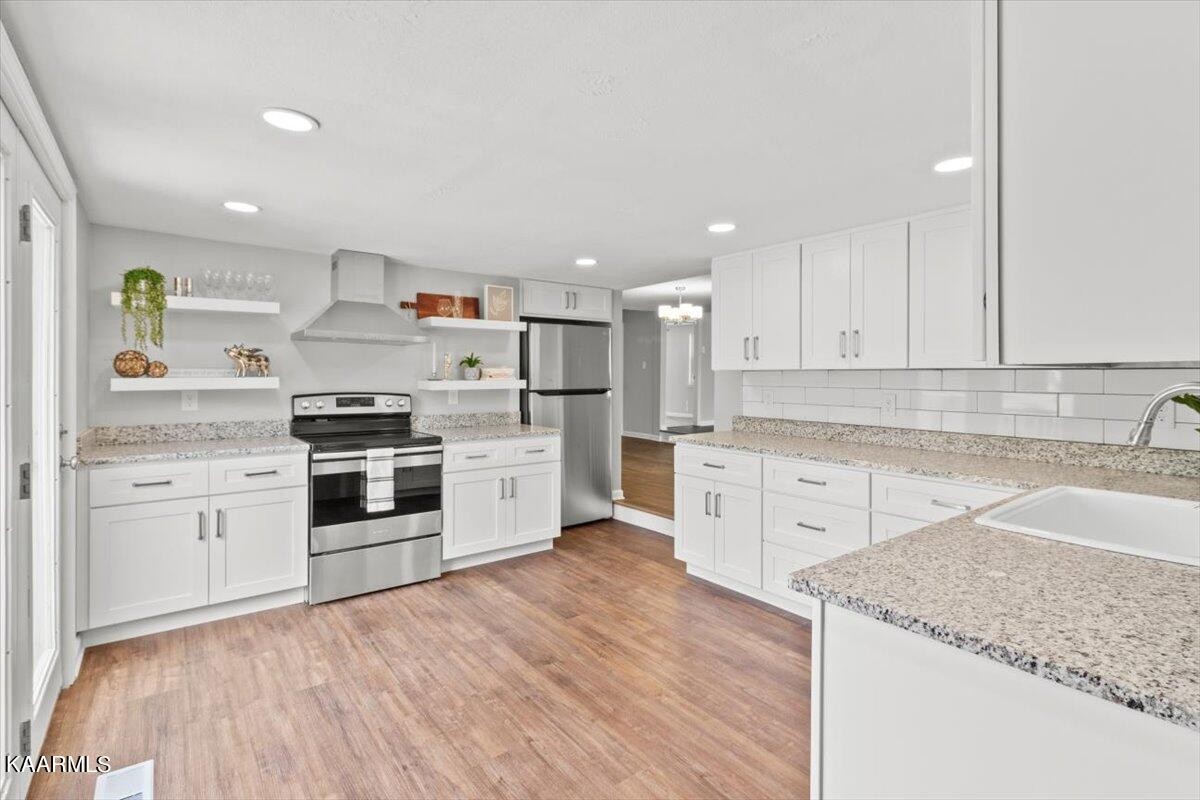316 Granite Road Clinton, TN 37716 - Photo 14 of 26 a kitchen with granite countertop white cabinets and stainless steel appliances