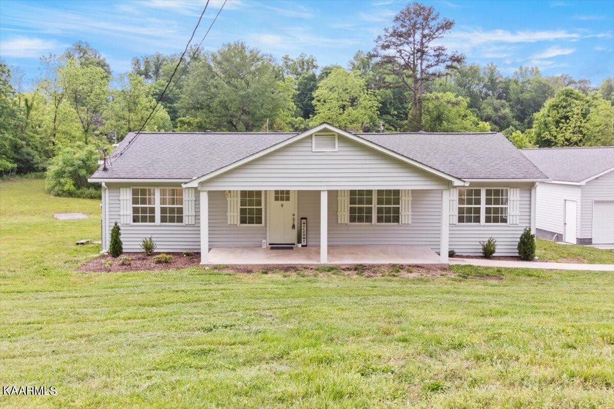 316 Granite Road Clinton, TN 37716 - Photo 24 of 26 a front view of a house with a garden and yard