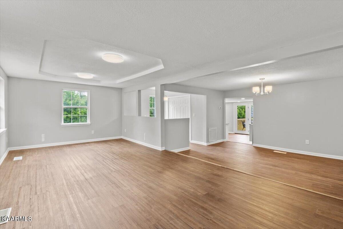 316 Granite Road Clinton, TN 37716 - Photo 6 of 26 an empty room with wooden floor and windows
