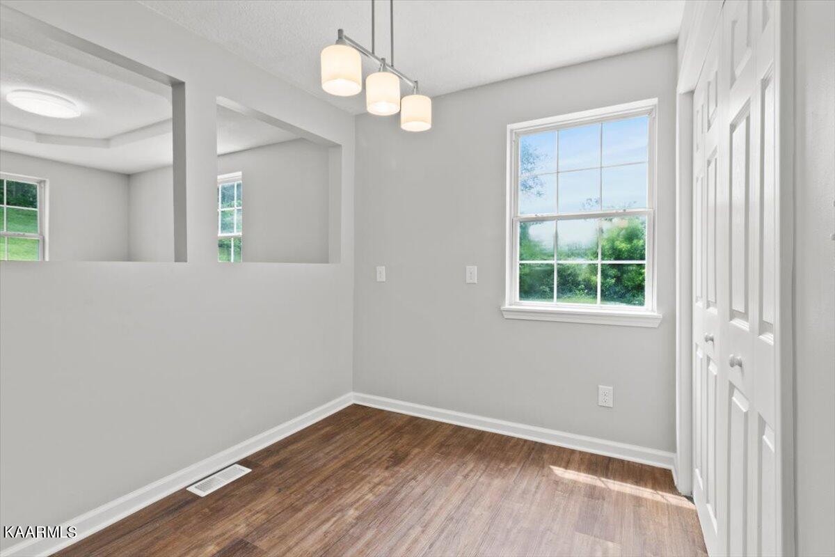 316 Granite Road Clinton, TN 37716 - Photo 9 of 26 an empty room with wooden floor and windows