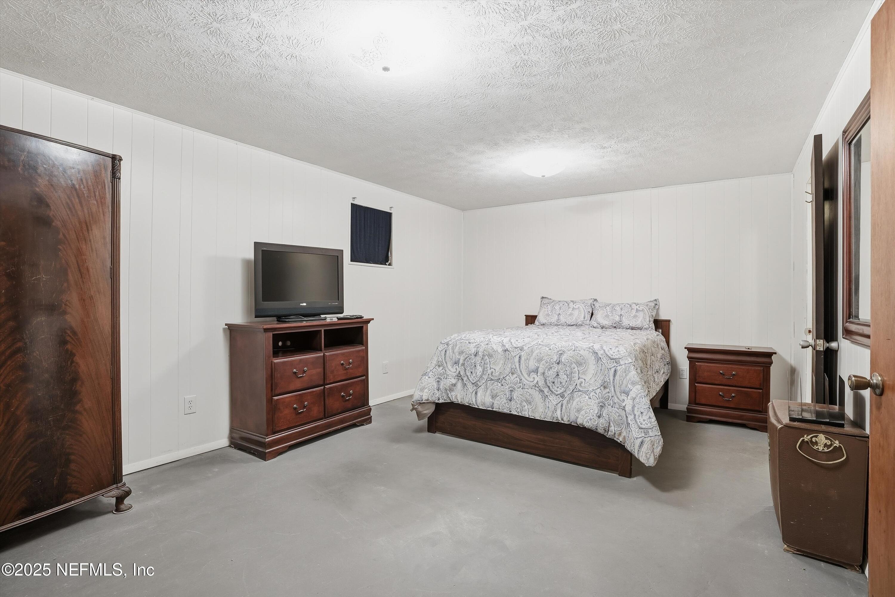11558 Raft Road Jacksonville, FL 32218 - Photo 12 of 32 a bedroom with a bed and a flat screen tv