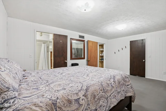 a large bedroom with a bed and a large mirror