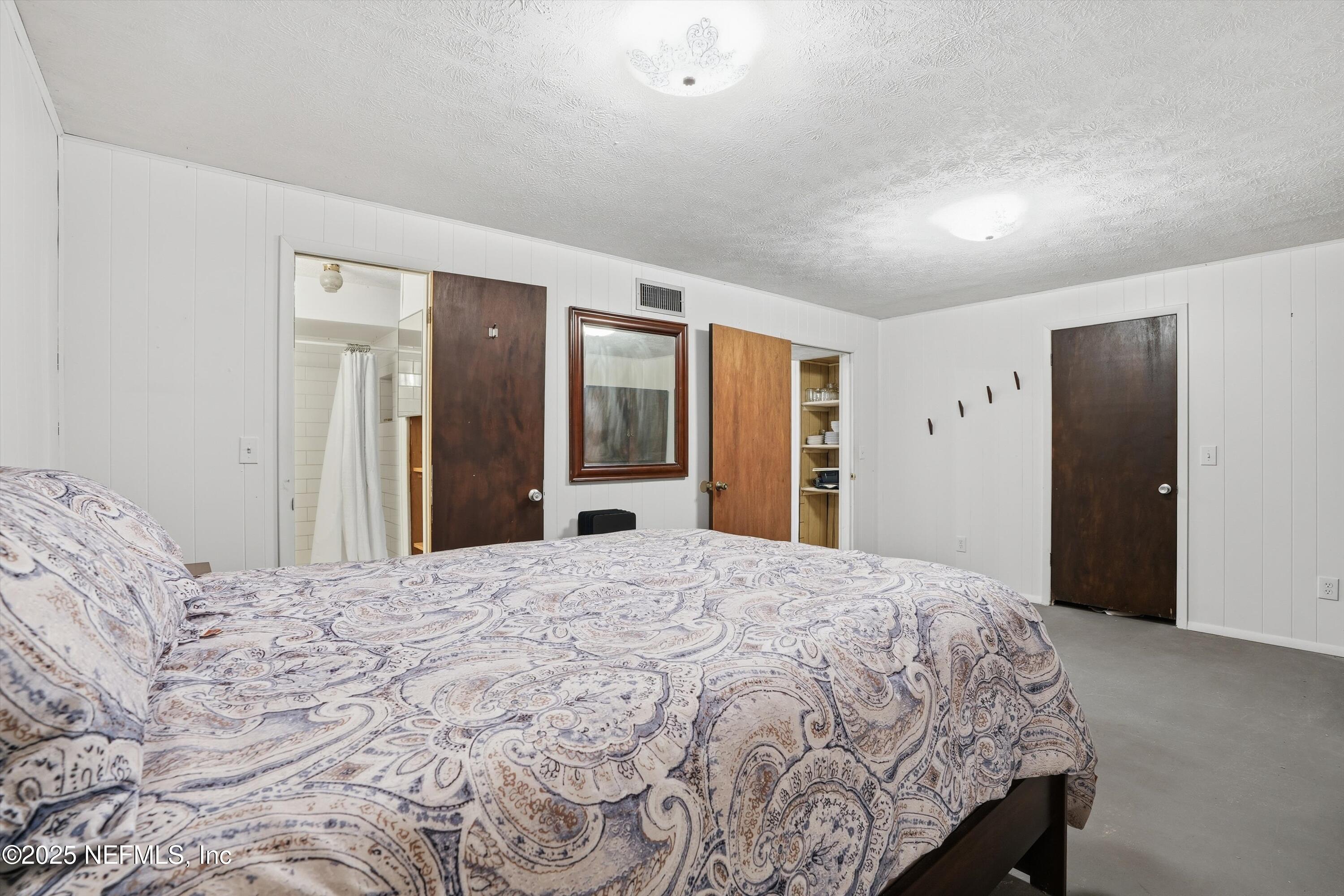 11558 Raft Road Jacksonville, FL 32218 - Photo 13 of 32 a large bedroom with a bed and a large mirror