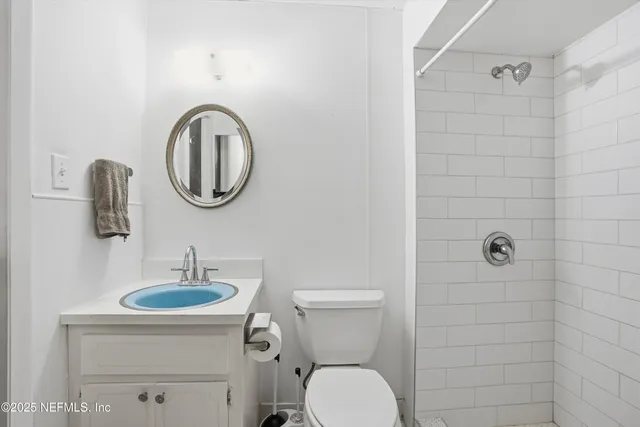 a bathroom with a toilet a sink and mirror