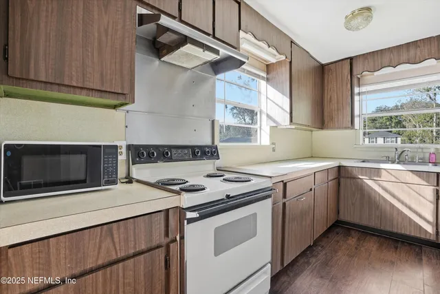 a kitchen that has a sink and a stove top oven