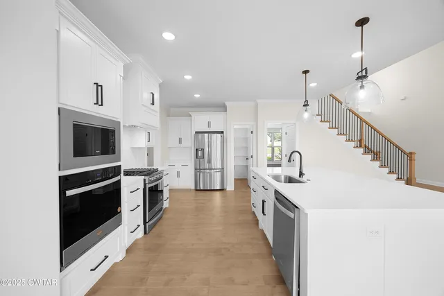 a kitchen with white cabinets appliances and sink
