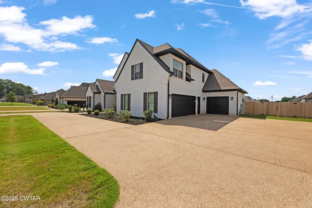 a front view of a house with a yard and mountain view
