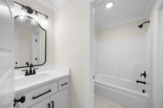 a bathroom with a tub sink and mirror