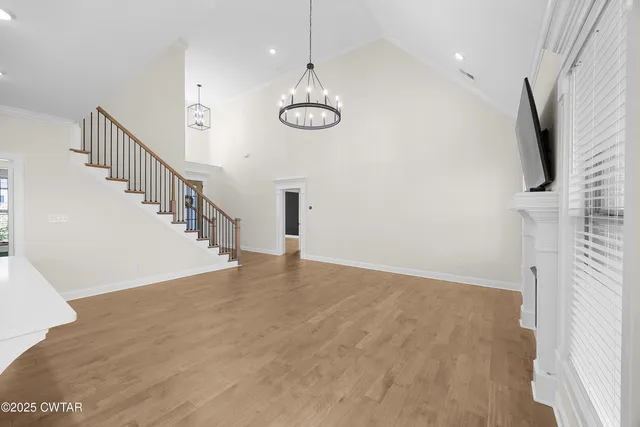 a view of a room with wooden floor and windows