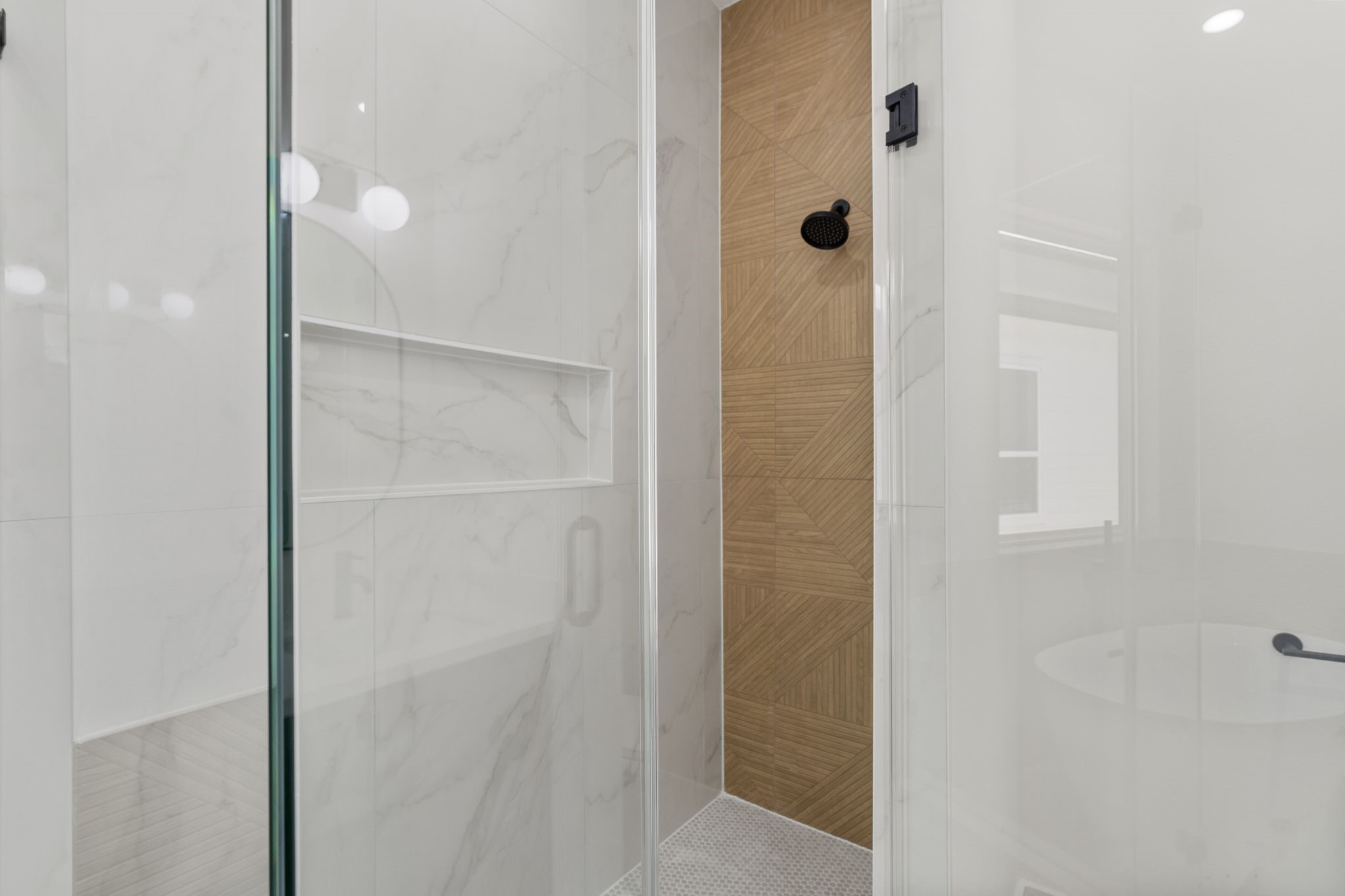 7321 Laura Koppe Road Houston, TX 77028 - Photo 19 of 41 Sleek and modern shower featuring elegant marble look
tiles and a stylish wood-patterned accent wall,
complemented by a matte black showerhead.
Spacious covered