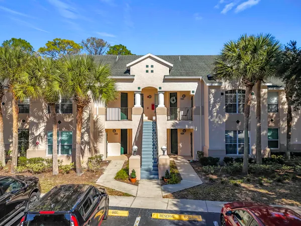 a front view of a building with streets and trees