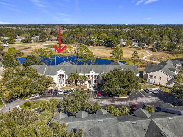 an aerial view of residential houses with outdoor space and ocean view