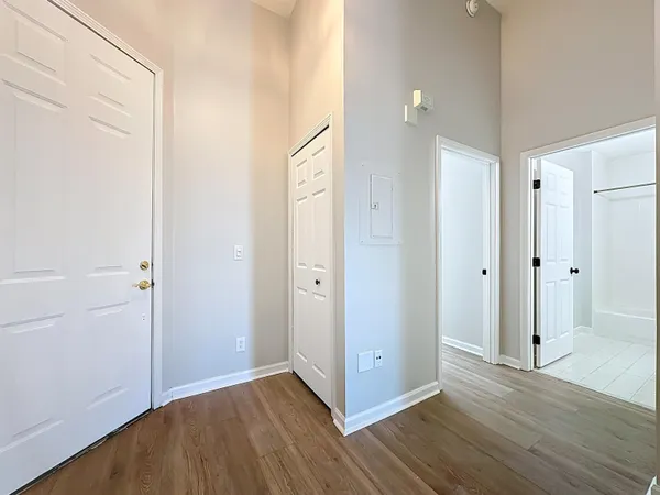 a view of an empty room with window and wooden floor