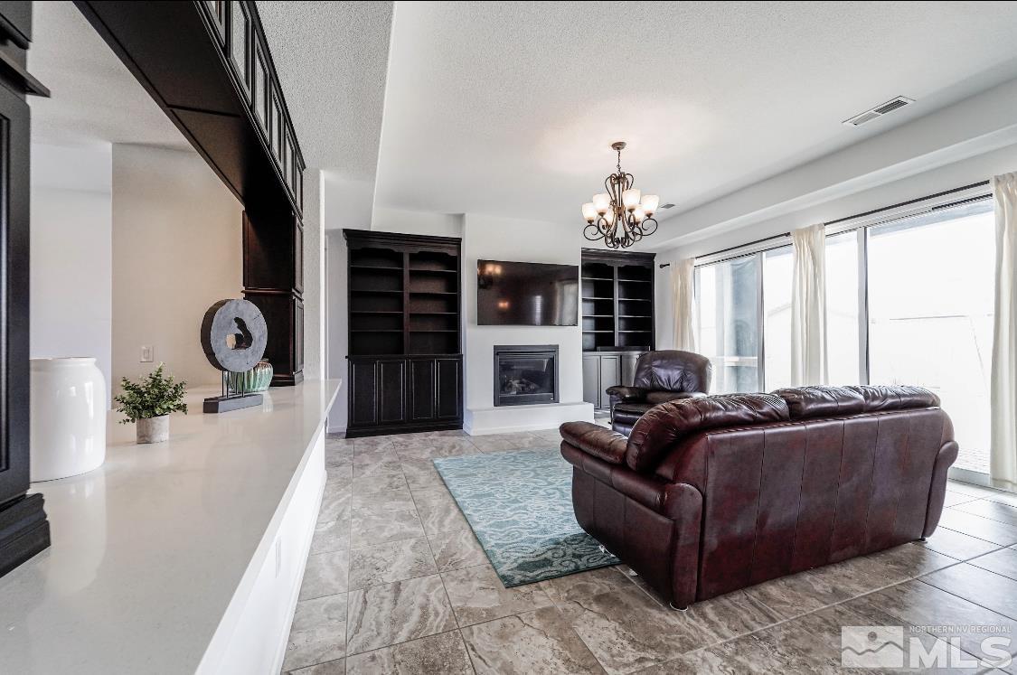 10080 Ellis Park Lane Reno, NV 89521 - Photo 3 of 26 a living room with furniture a fireplace and large windows